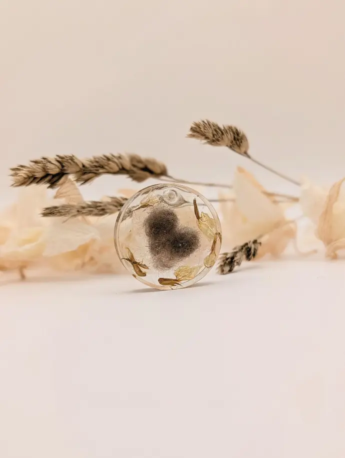 Porte clés rond en résine époxy avec incrustation de poils de popeye en forme de coeur et fleurs séhcé de muguet