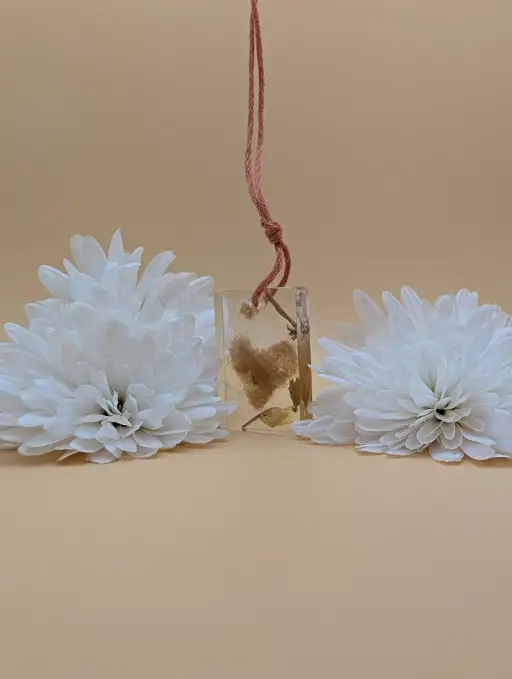 Porte clés mémoriel réctangulaire contenant des poils d'Hiver en forme de coeur avec des fleurs séché de muguet